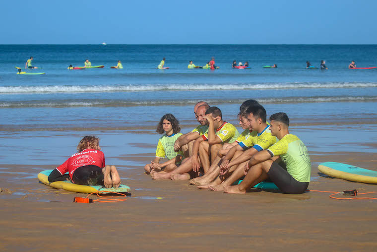 Explication sur le sable avant le cours de surf à Biarritz